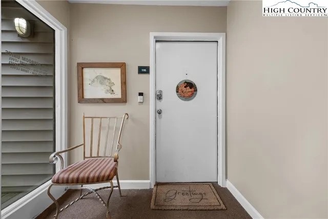 a view of a hallway with front door and wooden floor