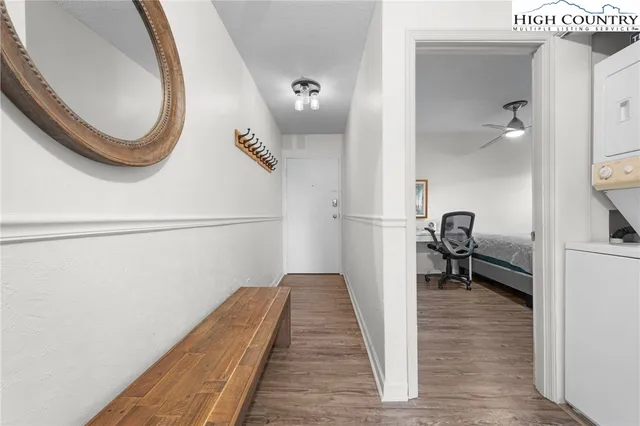 a hallway with a white cabinets and wooden floor