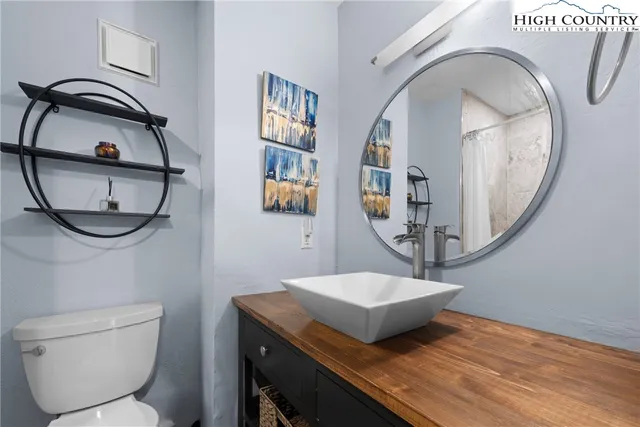 a bathroom with a toilet a sink and a mirror