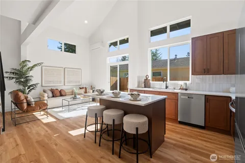 a view of a kitchen with granite countertop a dining table chairs and a wooden floor
