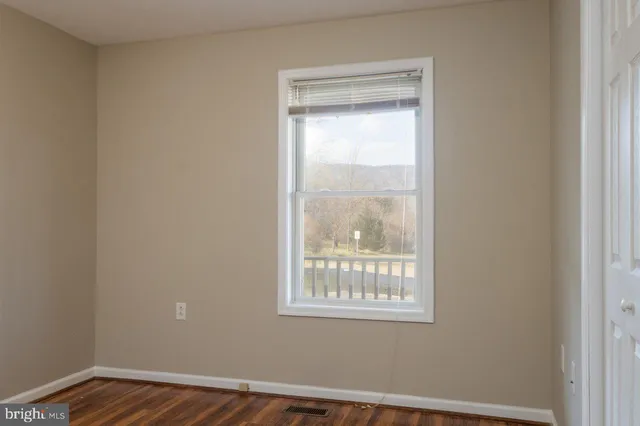 an empty room with wooden floor door and closet