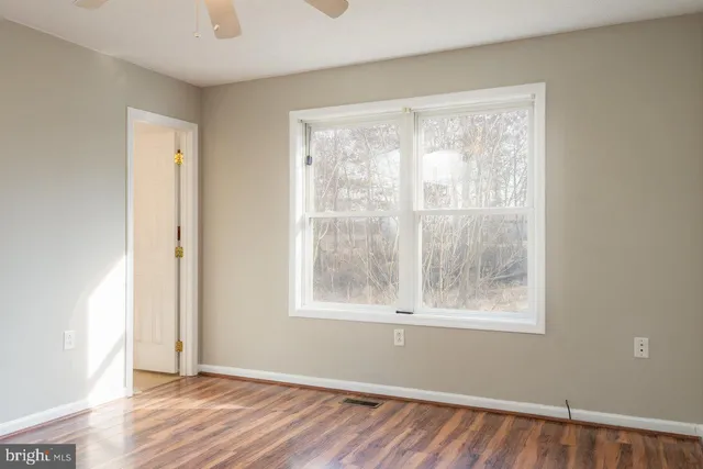 a view of empty room with wooden floor