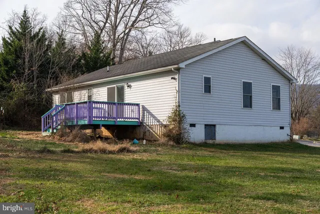 a view of a house with a yard and wooden fence