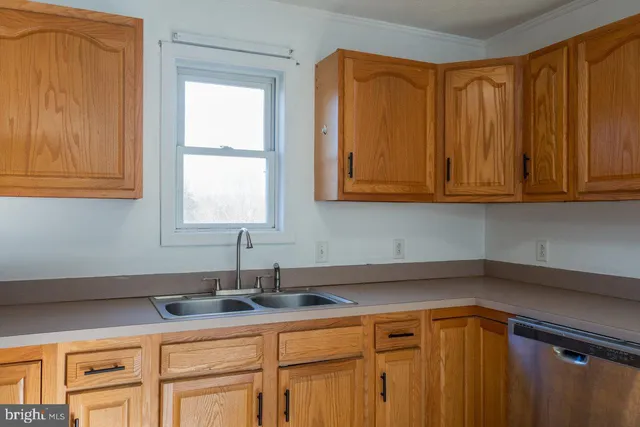 a kitchen with stainless steel appliances granite countertop white cabinets a sink and dishwasher