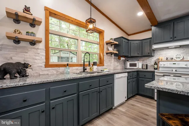 a kitchen with stainless steel appliances granite countertop wooden cabinets a sink and a stove