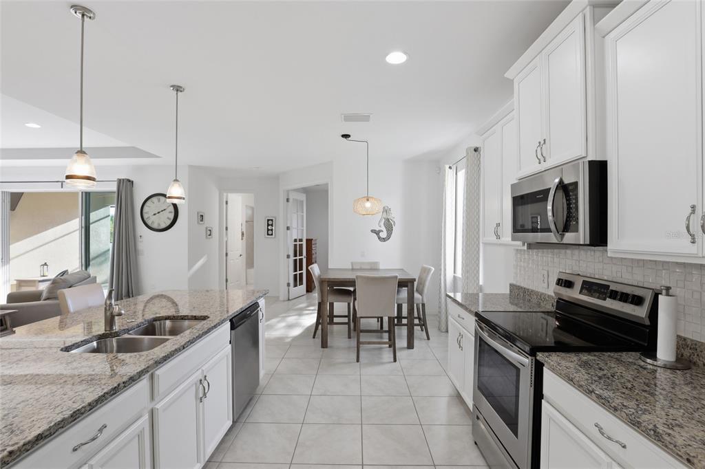 14879 Wichita Road Port Charlotte, FL 33981 - Photo 11 of 45 a kitchen with stainless steel appliances granite countertop a sink a stove and a wooden floors