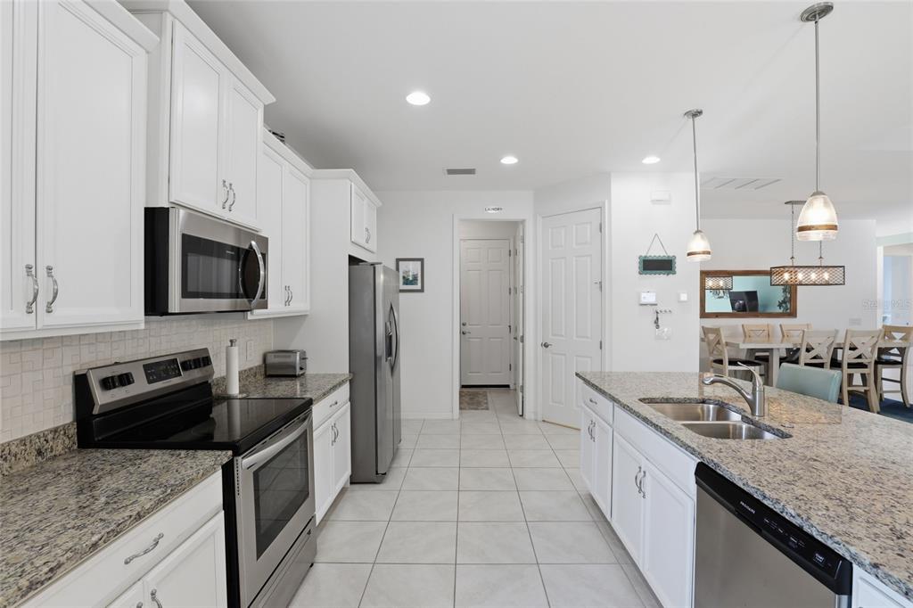 14879 Wichita Road Port Charlotte, FL 33981 - Photo 12 of 45 a kitchen with granite countertop a sink a counter top space stainless steel appliances and cabinets