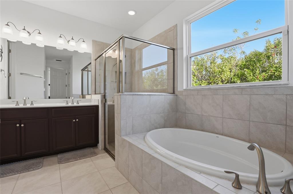 14879 Wichita Road Port Charlotte, FL 33981 - Photo 22 of 45 a spacious bathroom with a tub sink and mirror