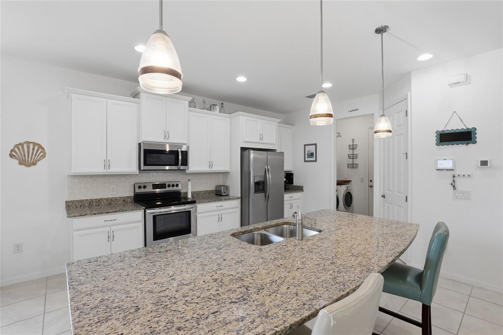 14879 Wichita Road Port Charlotte, FL 33981 - Photo 9 of 45 a kitchen with stainless steel appliances granite countertop a sink refrigerator and cabinets
