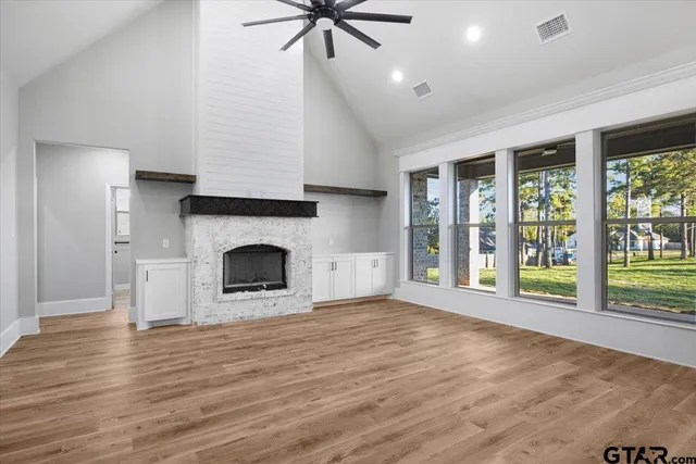 a view of an empty room with a fireplace and a window