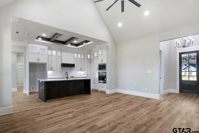 a large kitchen with stainless steel appliances granite countertop a refrigerator and a sink