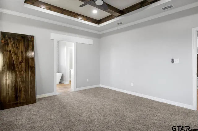 an empty room with a ceiling fan and carpet