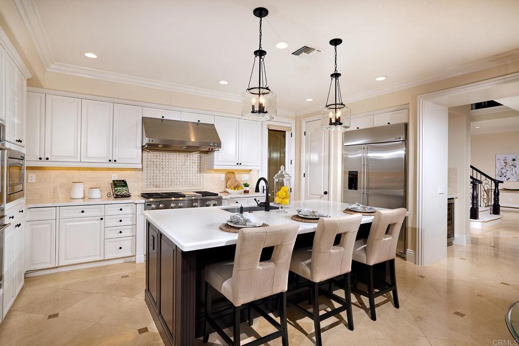 6895 Amber Lane Carlsbad, CA 92009 - Photo 13 of 45 a kitchen with stainless steel appliances kitchen island granite countertop a dining table chairs and sink