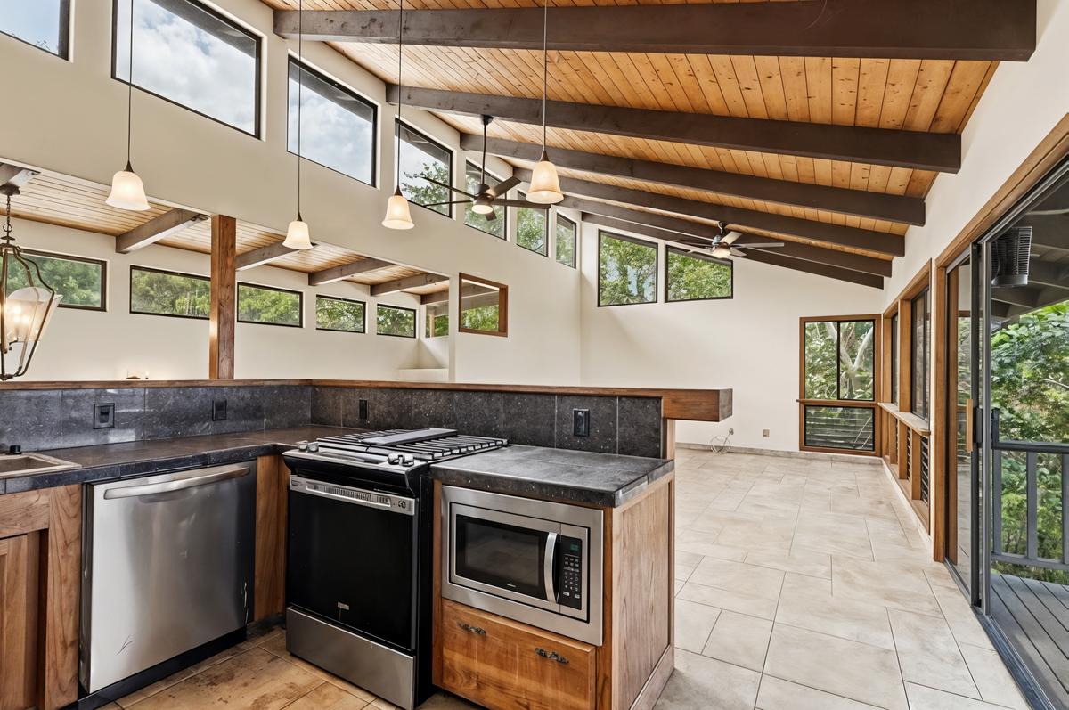 81-6315 Hawaiʻi Belt Road Captain Cook, HI 96750 - Photo 10 of 25 a kitchen with stainless steel appliances granite countertop a stove and a sink