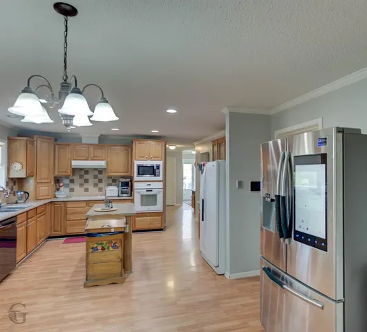 a kitchen with stainless steel appliances granite countertop a refrigerator and a stove
