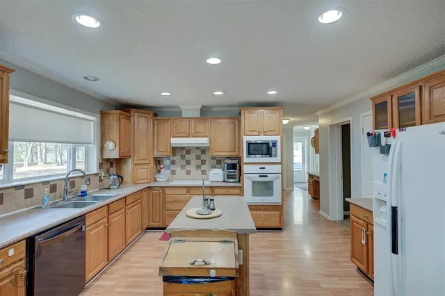 a kitchen with stainless steel appliances kitchen island granite countertop a refrigerator and a stove top oven