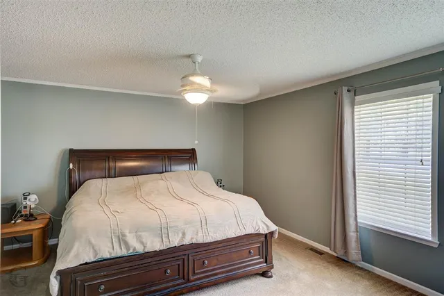 a bed sitting in a bedroom next to a window