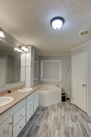 a spacious bathroom with a tub sink and a mirror