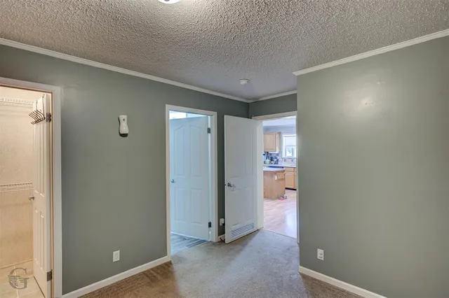 a view of a hallway with wooden floor and a door