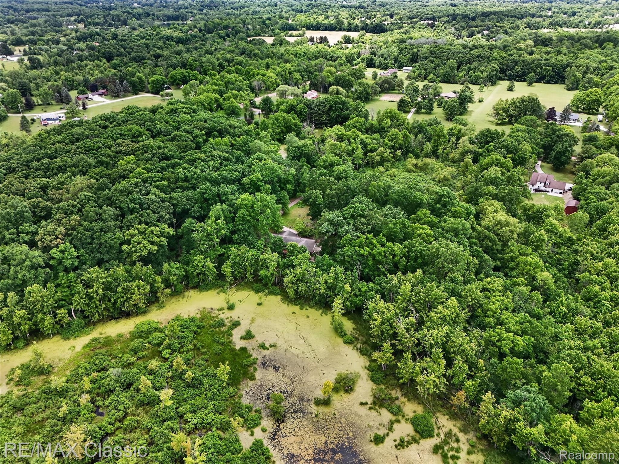 12189 Gage Road Holly, MI 48442 - Photo 65 of 69 Expansive aerial landscape highlighting a lush, tree-filled environment with scattered residential structures