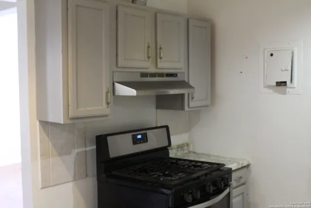 a stove top oven sitting inside of a kitchen