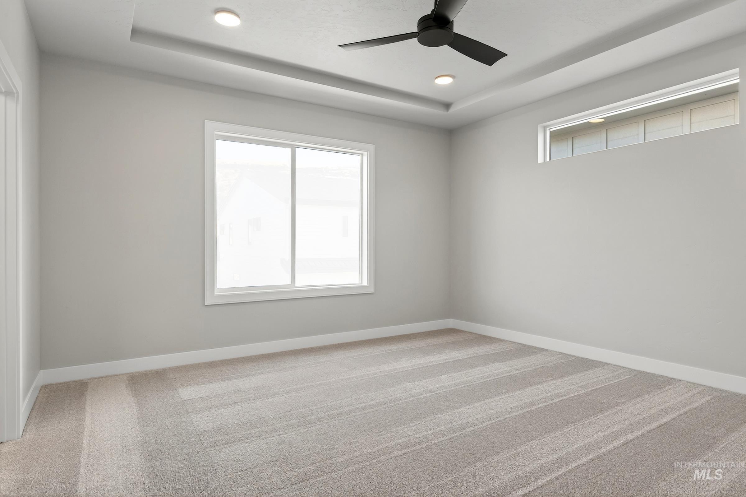 3374 West Neville Rnch Drive Boise, ID 83714 - Photo 20 of 37 Empty room with a tray ceiling, light colored carpet, recessed lighting, and a ceiling fan