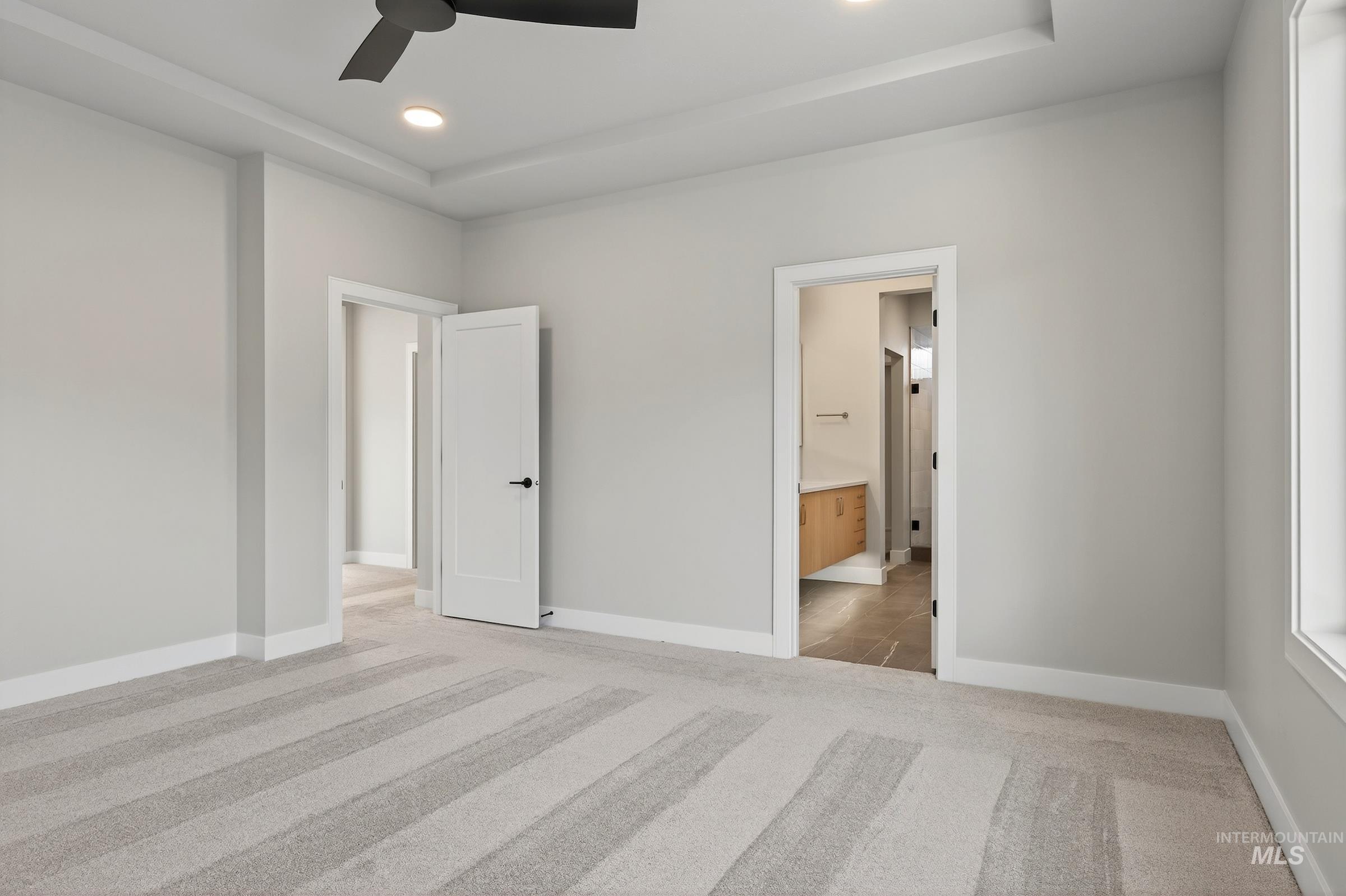 3374 West Neville Rnch Drive Boise, ID 83714 - Photo 21 of 37 Unfurnished bedroom featuring light carpet, ceiling fan, recessed lighting, a raised ceiling, and connected bathroom