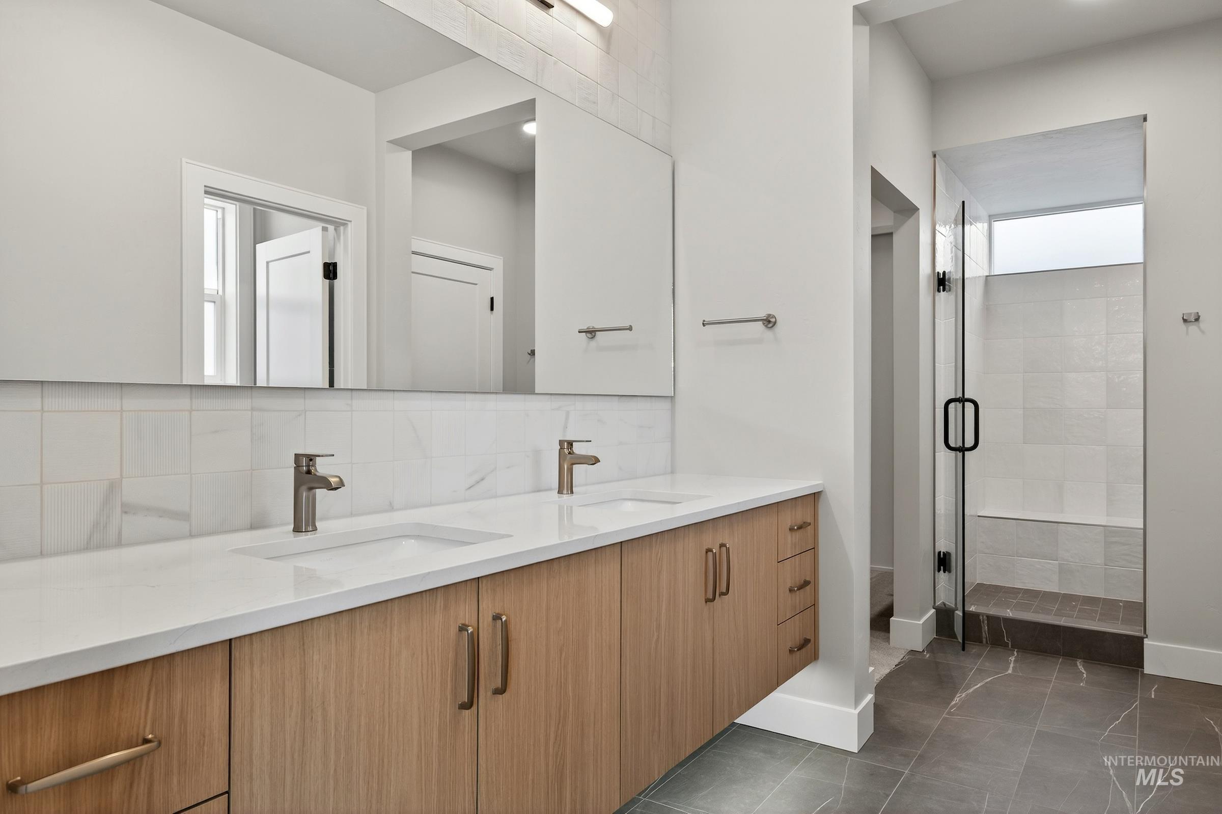 3374 West Neville Rnch Drive Boise, ID 83714 - Photo 22 of 37 Bathroom featuring double vanity, backsplash, a stall shower, and dark tile patterned flooring