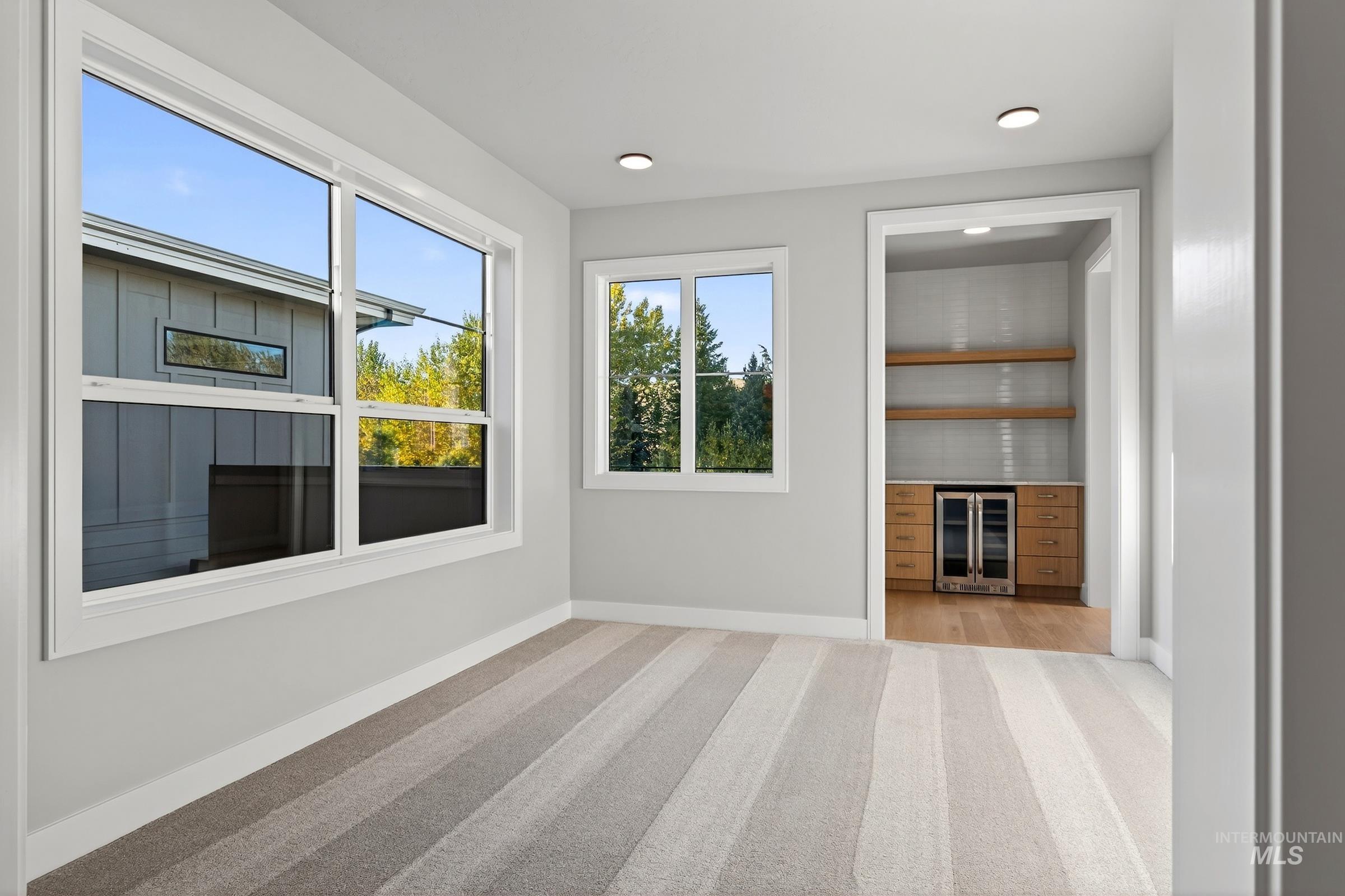 3374 West Neville Rnch Drive Boise, ID 83714 - Photo 24 of 37 Unfurnished living room with light colored carpet, wine cooler, and recessed lighting