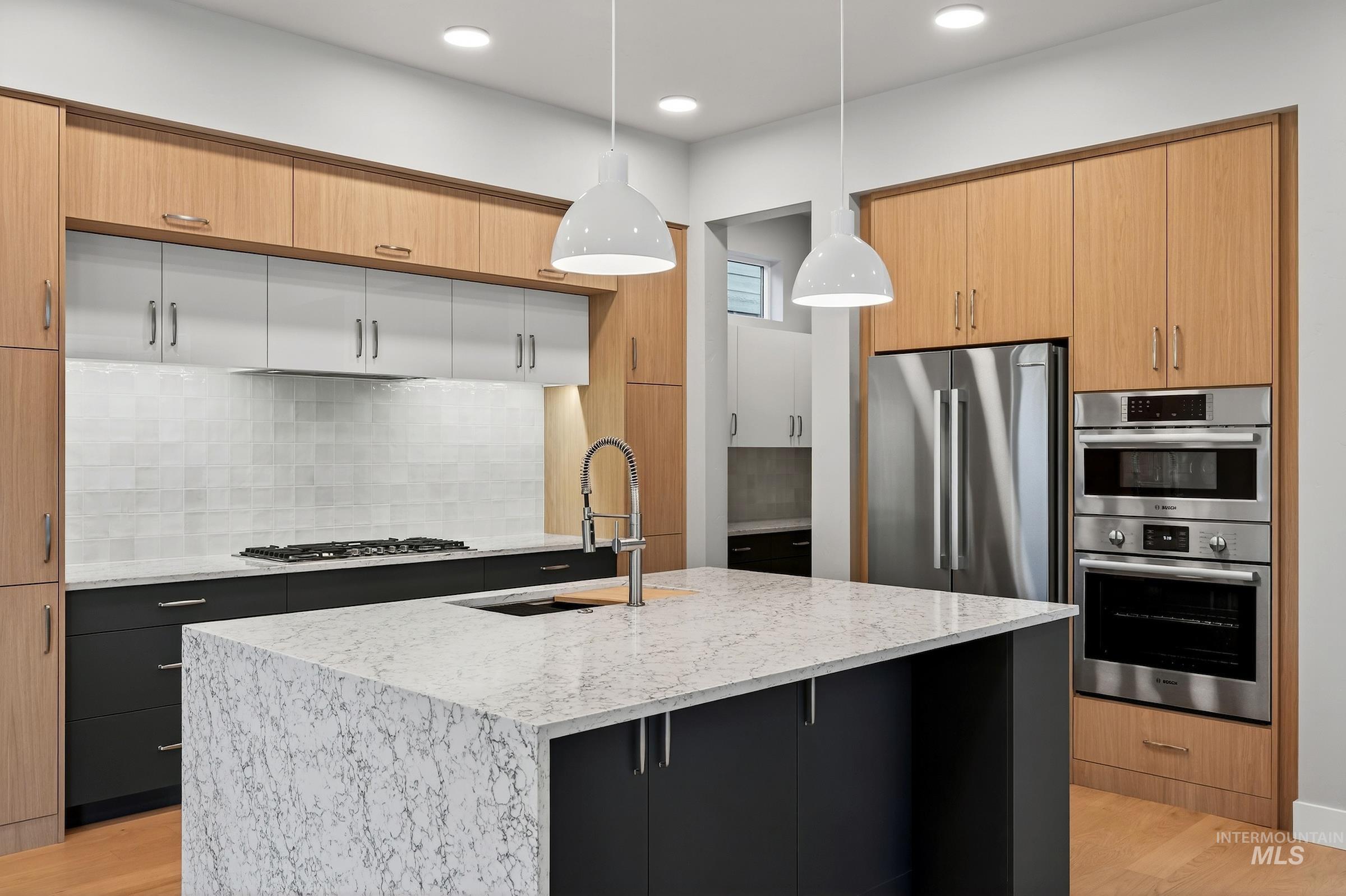 3374 West Neville Rnch Drive Boise, ID 83714 - Photo 2 of 37 Kitchen featuring light wood-style floors, pendant lighting, backsplash, light stone countertops, and recessed lighting