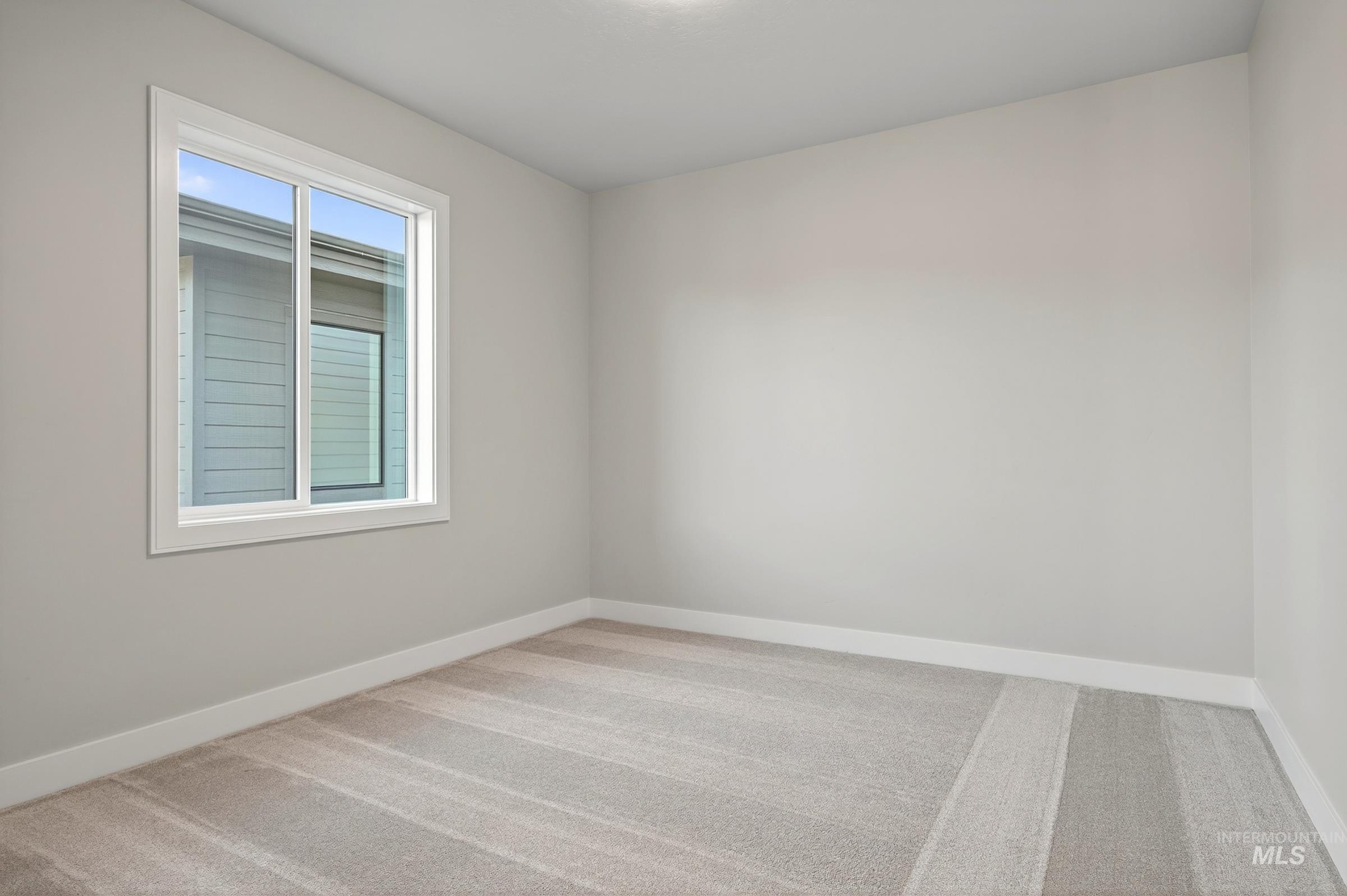 3374 West Neville Rnch Drive Boise, ID 83714 - Photo 32 of 37 Empty room with light colored carpet and baseboards