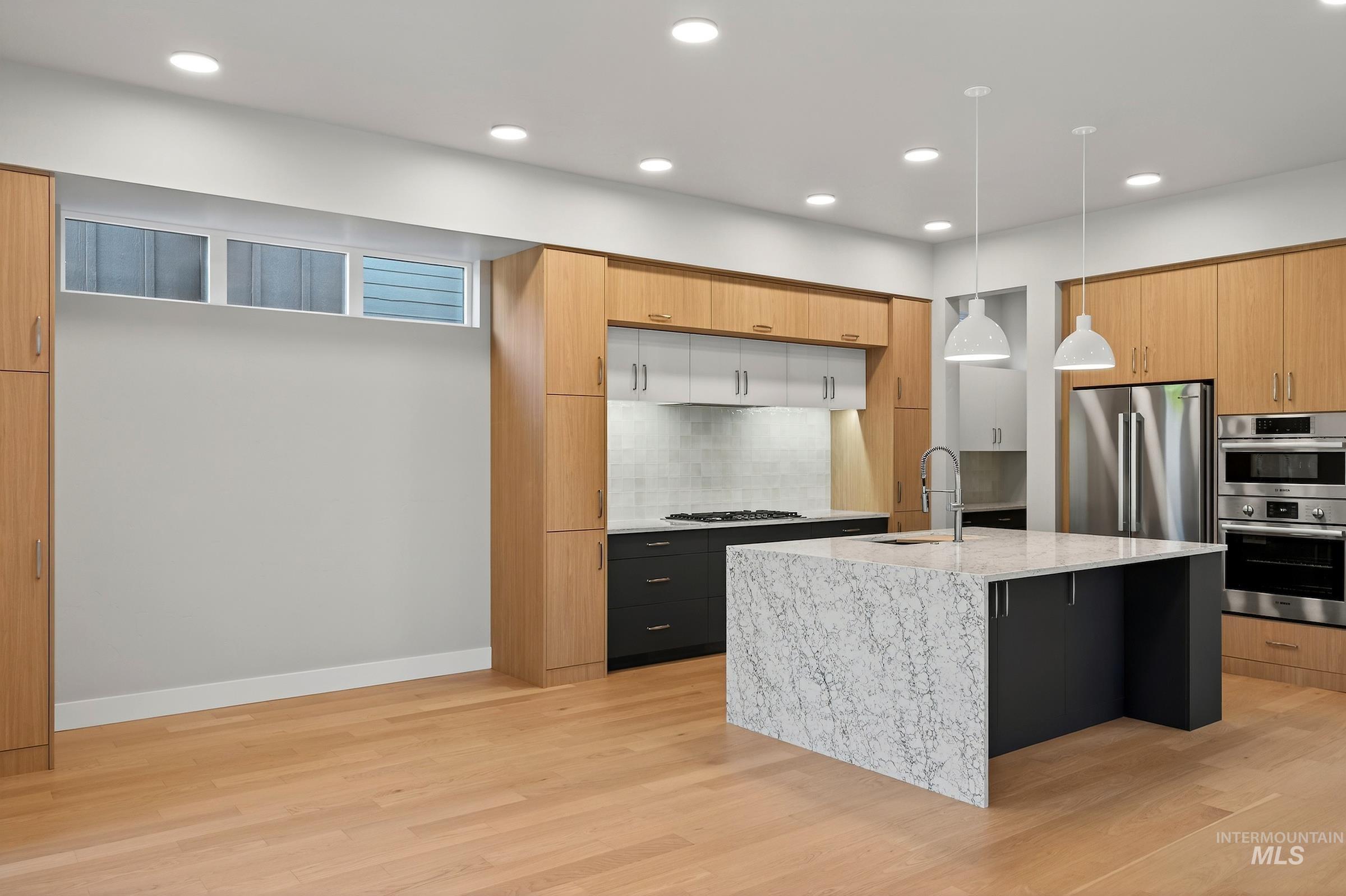 3374 West Neville Rnch Drive Boise, ID 83714 - Photo 3 of 37 Kitchen with pendant lighting, appliances with stainless steel finishes, light stone counters, recessed lighting, and a center island with sink