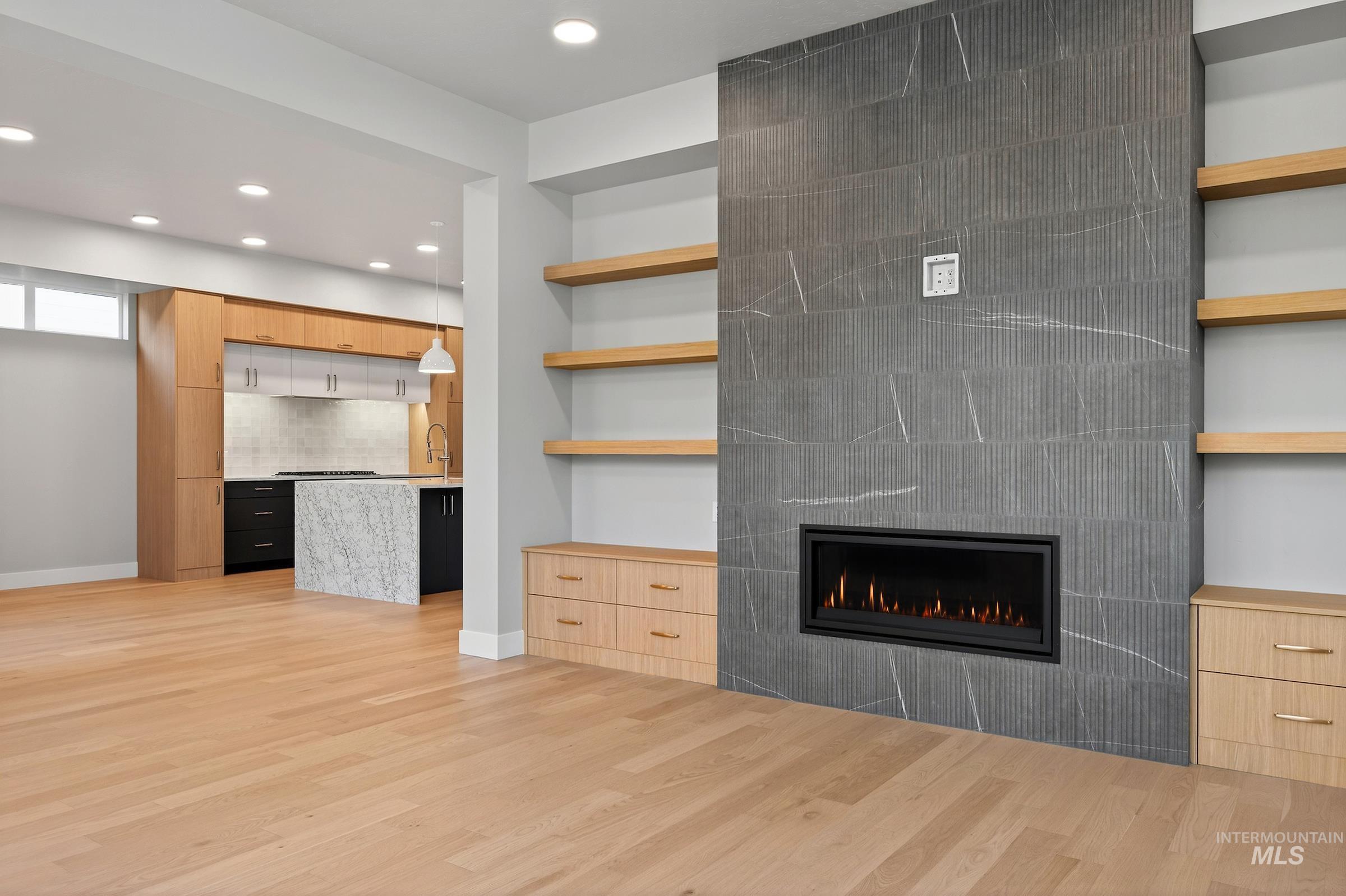 3374 West Neville Rnch Drive Boise, ID 83714 - Photo 5 of 37 Unfurnished living room with light wood-type flooring, recessed lighting, built in shelves, and a tiled fireplace