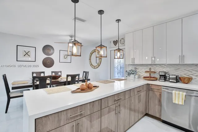 a kitchen with white cabinets and clock