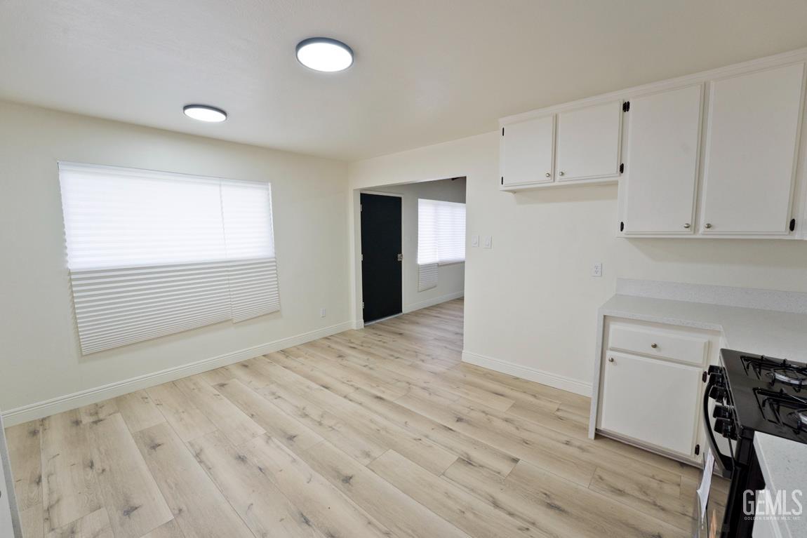 Undisclosed Address Wasco, CA 93280 - Photo 1 of 12 a view of an empty room with wooden floor and cabinet