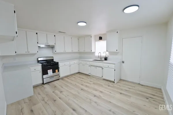 a kitchen with white cabinets and appliances