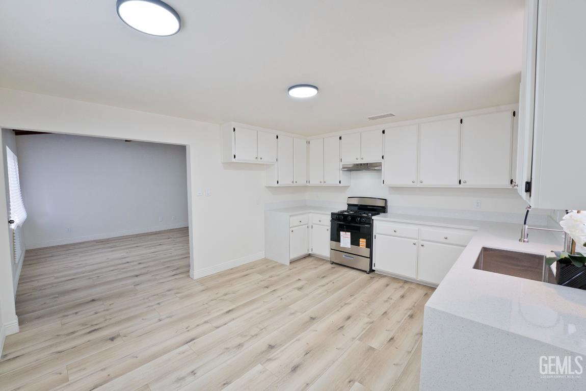 Undisclosed Address Wasco, CA 93280 - Photo 12 of 12 a kitchen with a refrigerator a stove top oven and white cabinets