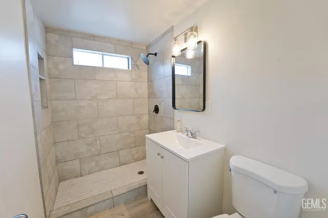 a bathroom with a sink a toilet and shower
