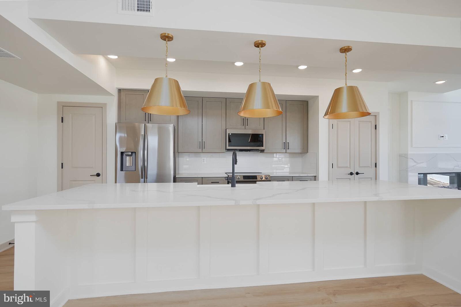 710 D Iron Frg Road Frederick, MD 21702 - Photo 12 of 43 a kitchen with kitchen island a stove and a wooden floors