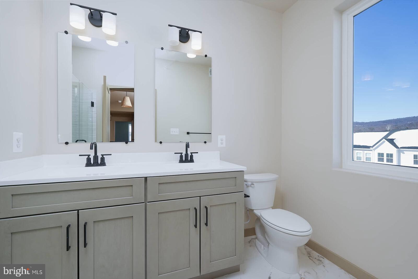 710 D Iron Frg Road Frederick, MD 21702 - Photo 29 of 43 a bathroom with a toilet a sink a mirror a window and vanity