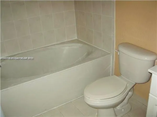 a white toilet sitting next to a bath tub