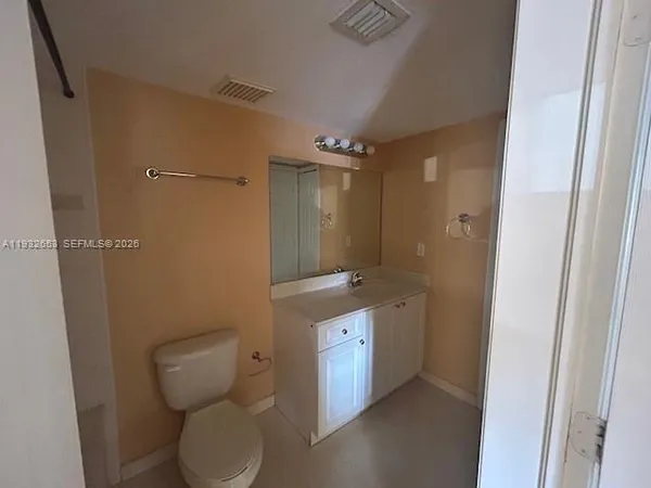 a view of an empty room with window and closet area