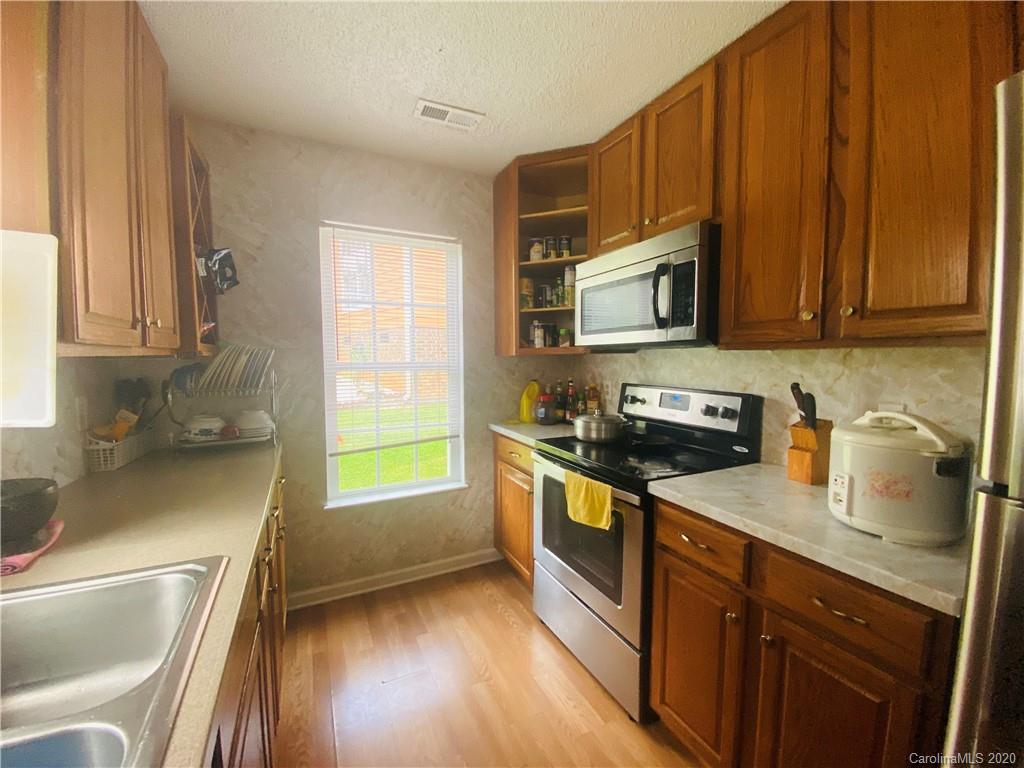 7121 Rena Mae Lane Charlotte, NC 28227 - Photo 15 of 21 a kitchen with granite countertop wooden cabinets stainless steel appliances a sink and a window