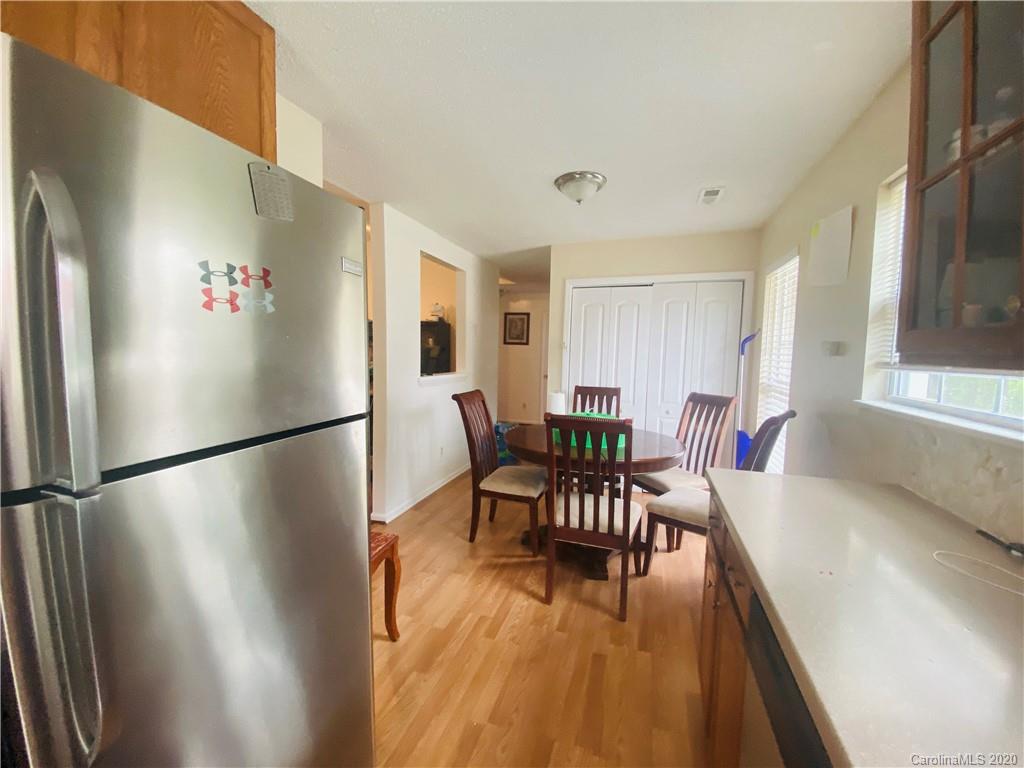 7121 Rena Mae Lane Charlotte, NC 28227 - Photo 16 of 21 a kitchen with stainless steel appliances granite countertop a refrigerator a stove a dining table and chairs