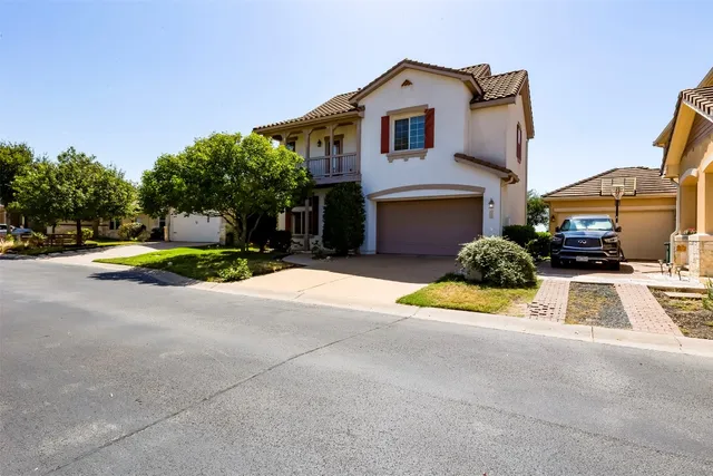 a view of a white house with a yard and plants