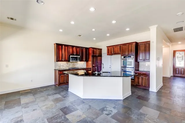 a large kitchen with a large counter top appliances and cabinets