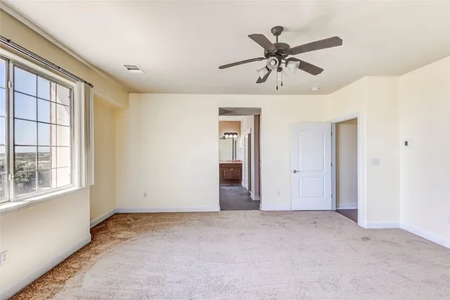 a view of empty room with ceiling fan