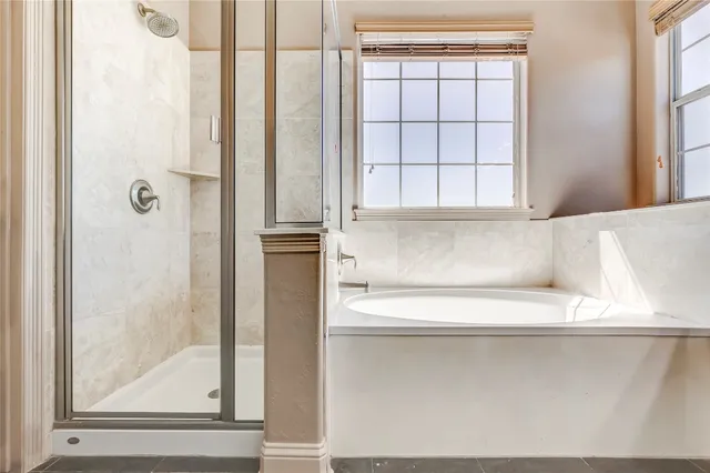 a spacious bathroom with a tub sink and mirror