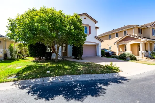 a front view of a house with a yard and garage