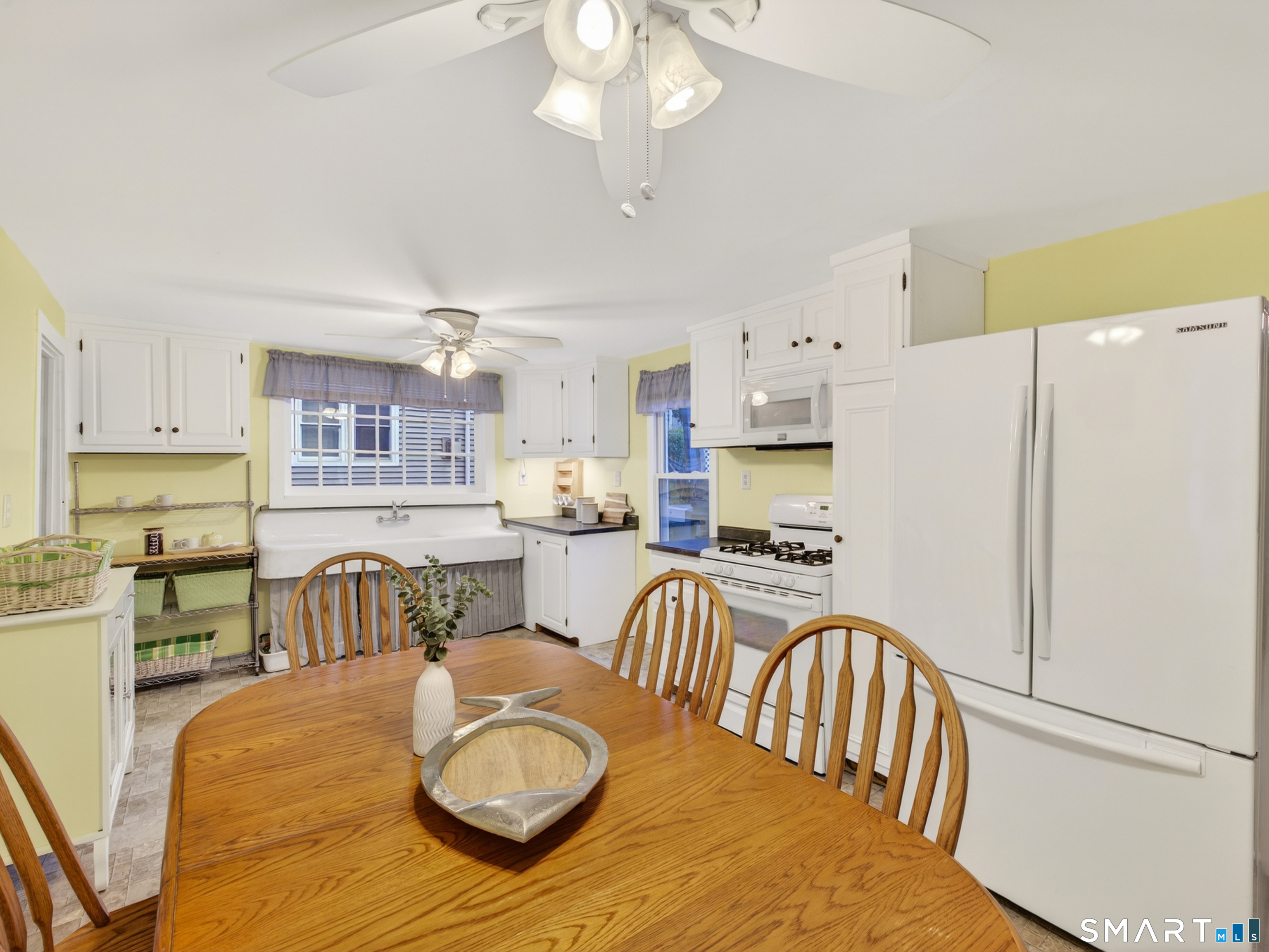 31 Old Colony Road Old Lyme, CT 06371 - Photo 12 of 38 a kitchen with stainless steel appliances granite countertop a refrigerator a stove a sink a dining table and chairs with wooden floor